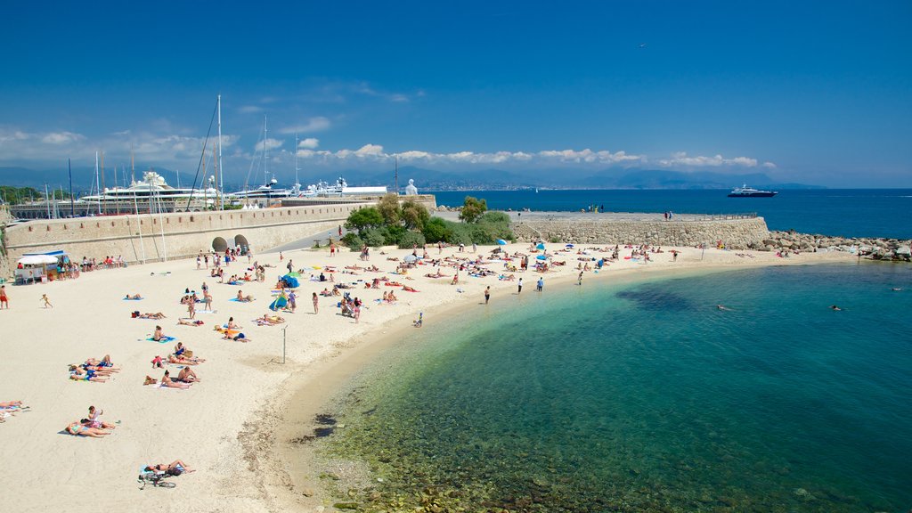 Antibes som inkluderer strand i tillegg til en stor gruppe med mennesker