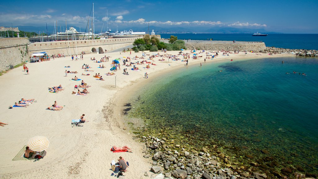 Antibes showing a sandy beach as well as a large group of people