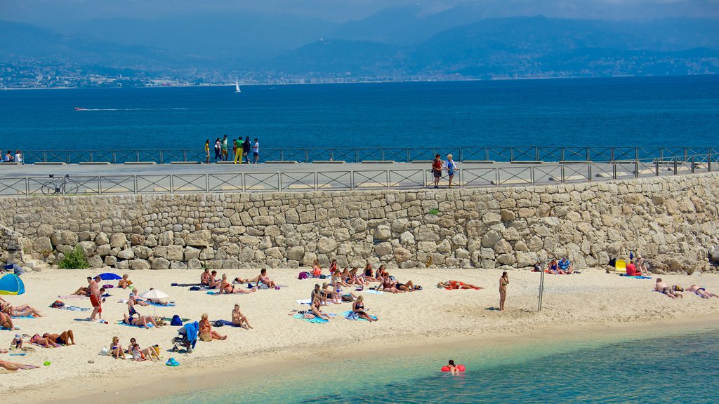 Antibes som inkluderer sandstrand og utsikt i tillegg til en stor gruppe med mennesker