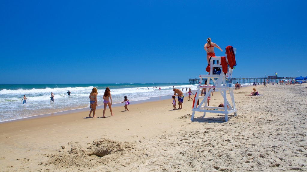 Ocean City Beach que incluye olas y una playa de arena y también un pequeño grupo de personas