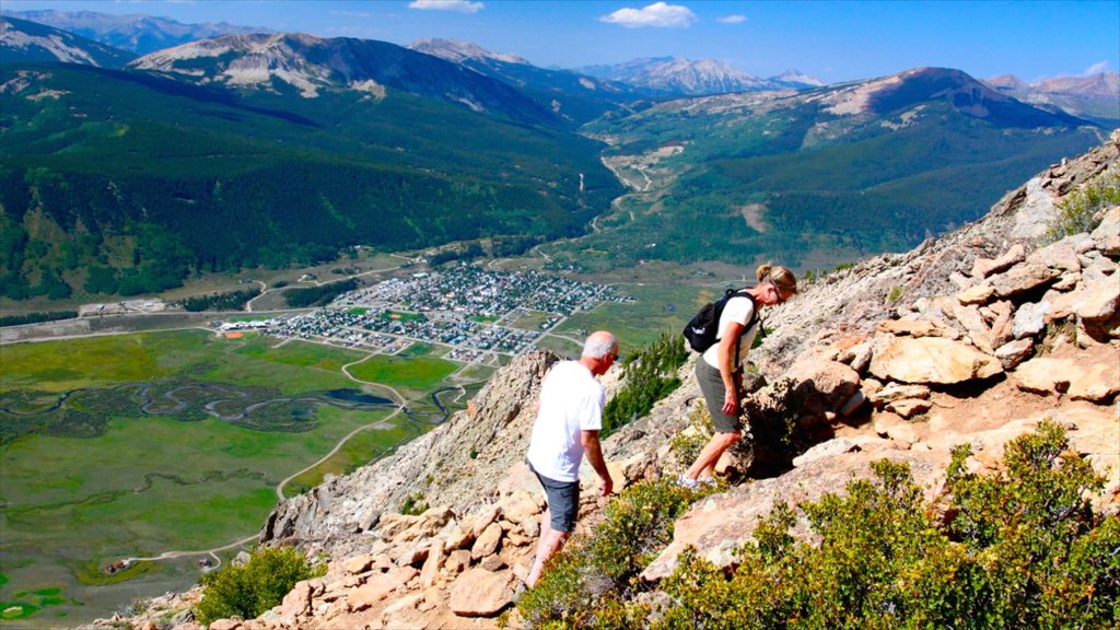 Crested Butte Mountain Resort som viser vandring eller fottur og fjell i tillegg til en liten gruppe med mennesker