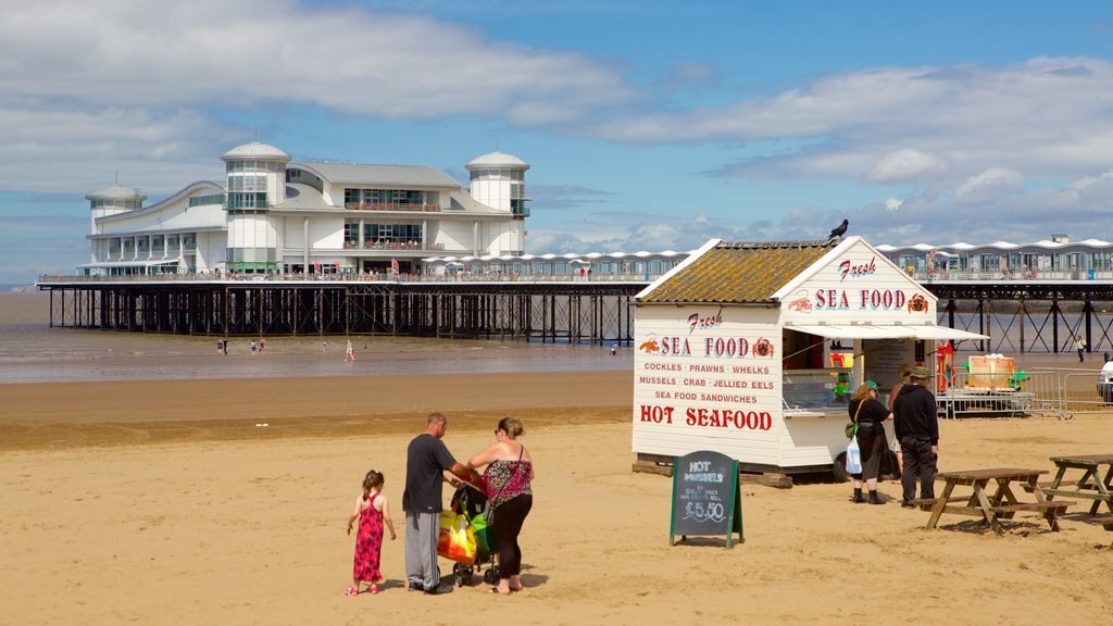 The Grand Pier mostrando uma praia, sinalização e jantar ao ar livre