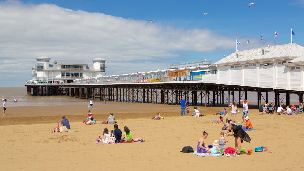 The Grand Pier which includes a sandy beach and views as well as a large group of people