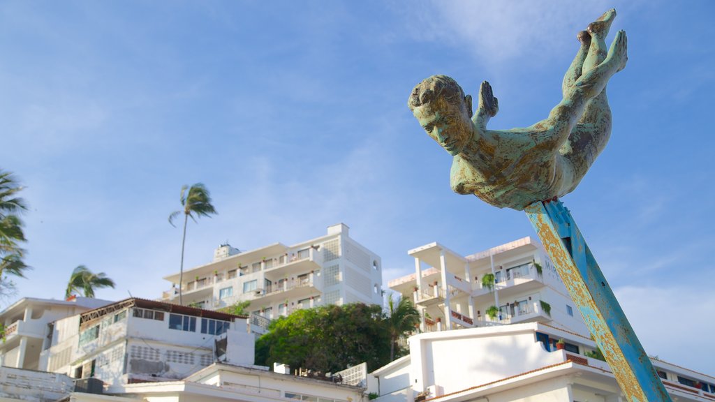 La Quebrada Cliffs featuring a coastal town and a statue or sculpture