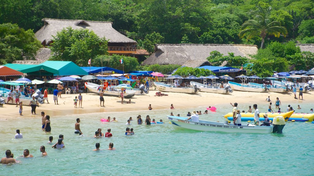 Puerto Angelito Beach showing a coastal town, a sandy beach and swimming