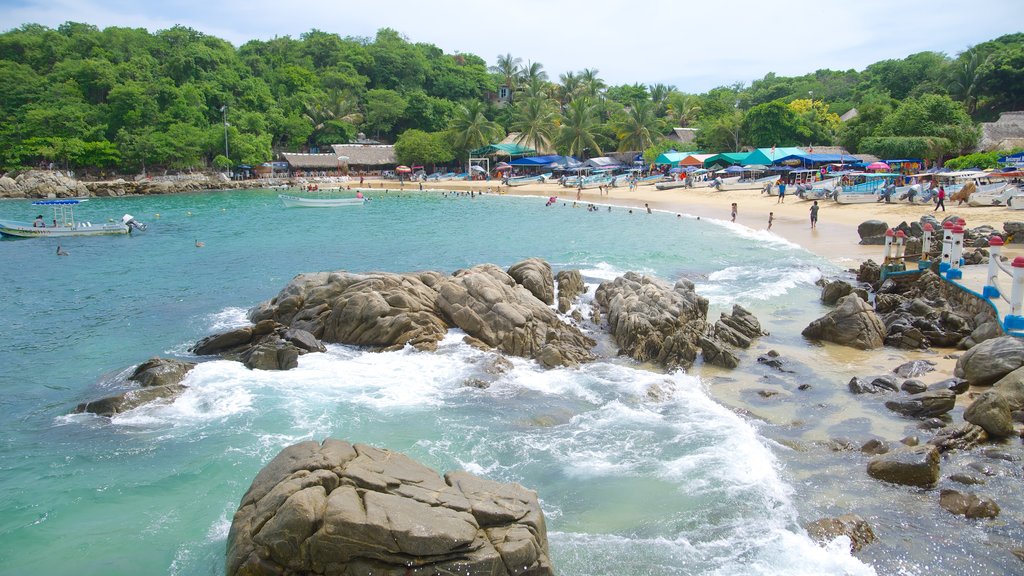 Puerto Angelito Beach which includes a beach, a coastal town and rocky coastline