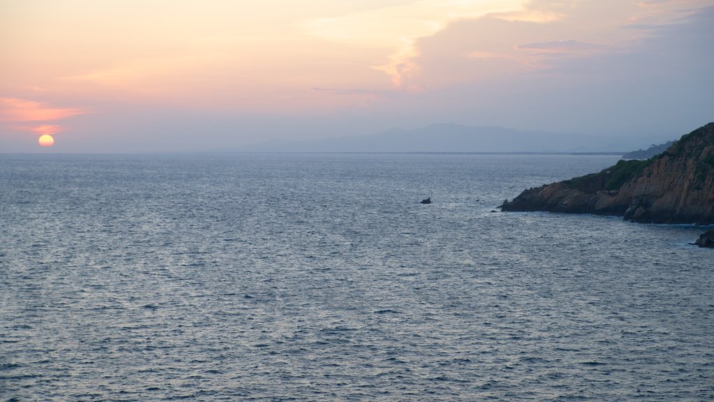 Sinfonía caracterizando um pôr do sol, litoral rochoso e paisagem