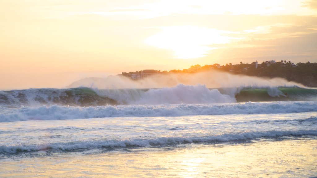 Playa Zicatela mostrando una puesta de sol, vistas generales de la costa y olas