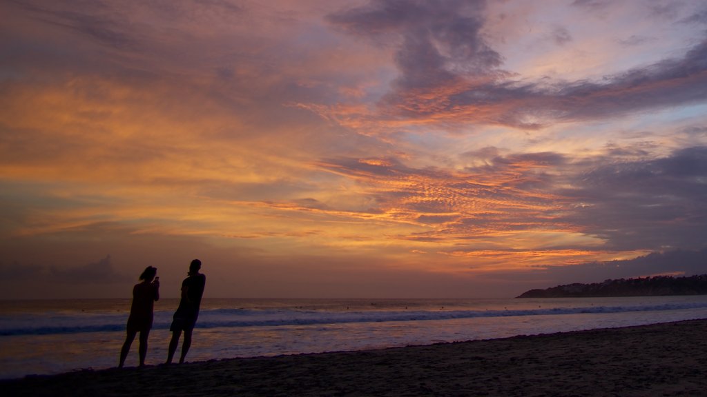 Zicatela Beach montrant coucher de soleil et plage de sable aussi bien que couple