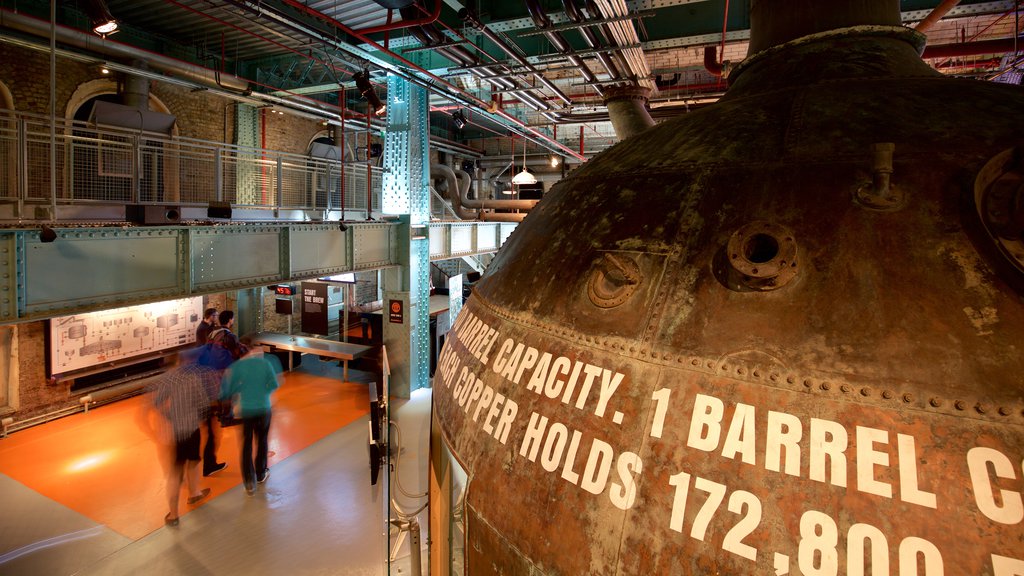 Guinness Storehouse som viser skilt og innendørs i tillegg til en liten gruppe med mennesker