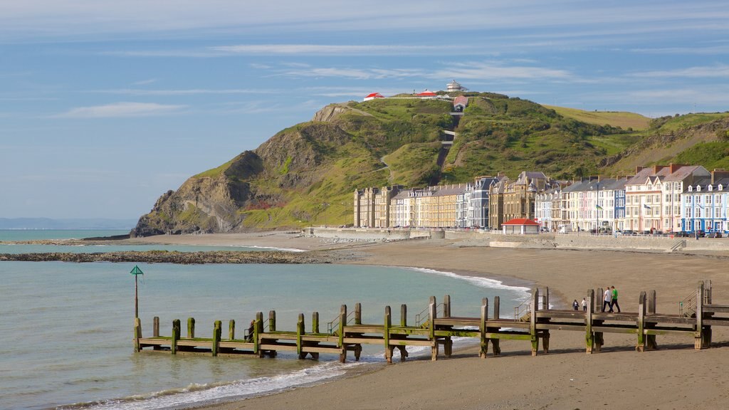 Aberystwyth mostrando uma baía ou porto, uma praia de areia e uma cidade litorânea