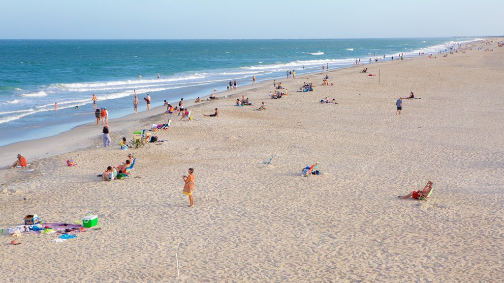 Wrightsville Beach que incluye una playa y vistas generales de la costa y también un gran grupo de personas