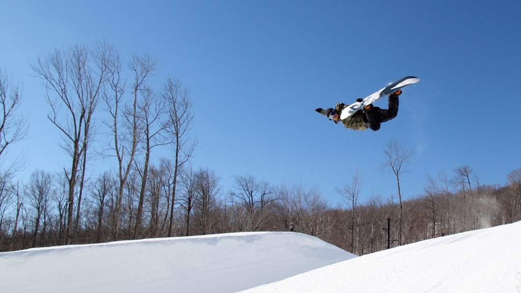 Club de golf Okemo Valley ofreciendo snowboard y nieve y también un hombre