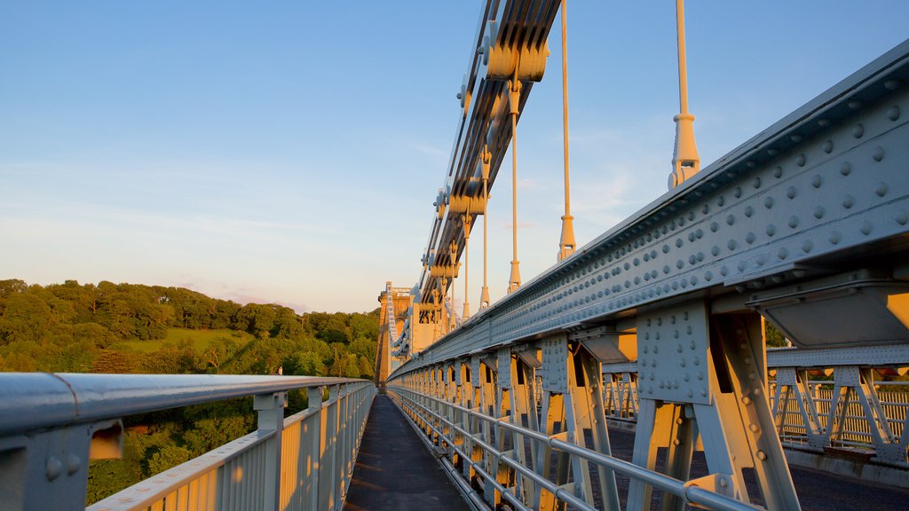 Menai Bridge featuring a sunset and a bridge