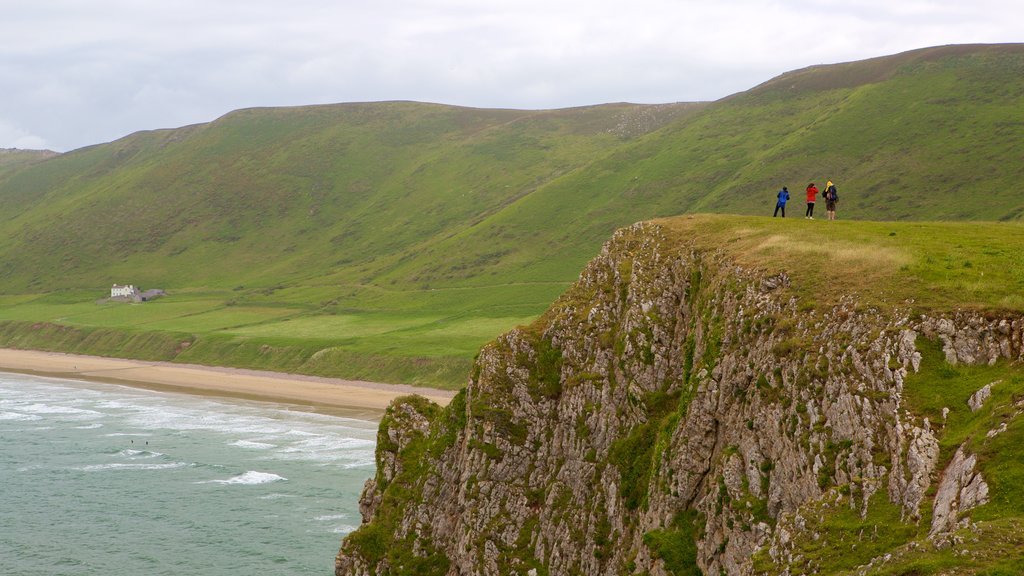 Rhossili Beach which includes mountains, general coastal views and a sandy beach