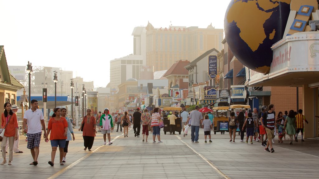 Atlantic City Boardwalk showing street scenes and rides as well as a large group of people