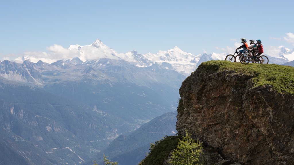 Crans-Montana Ski Resort featuring mountain biking and mountains as well as a small group of people