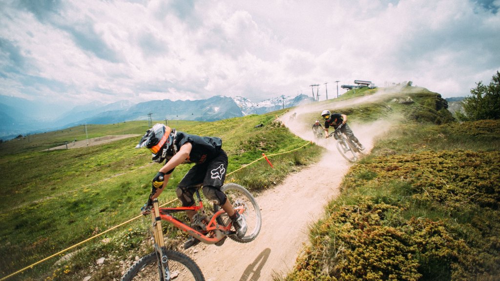 Crans-Montana Ski Resort showing mountain biking and farmland as well as a small group of people