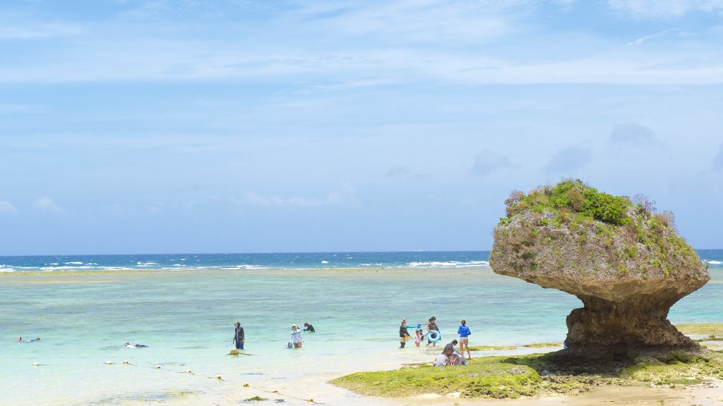 Playa Nirai mostrando una playa de arena y también un gran grupo de personas