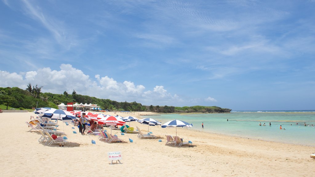 Playa Nirai que incluye una playa de arena y también un gran grupo de personas