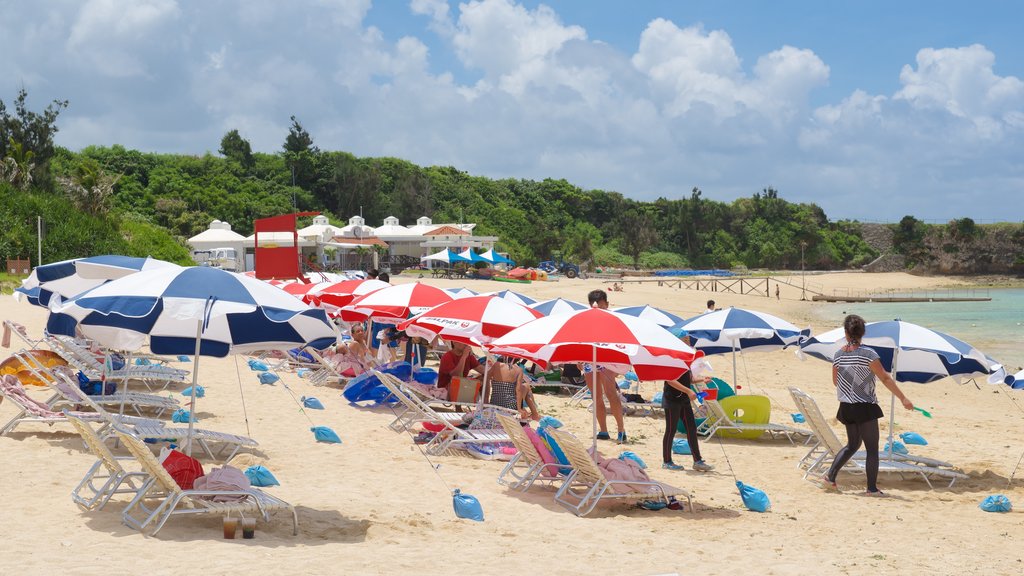 Nirai Beach showing a sandy beach as well as a large group of people