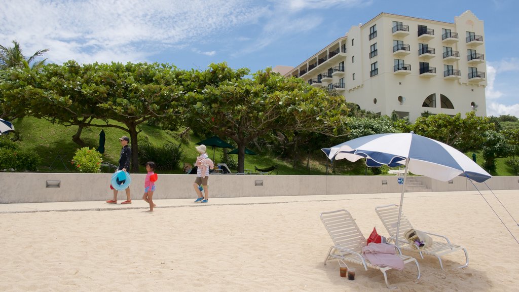 Nirai Beach showing a sandy beach and a hotel as well as children