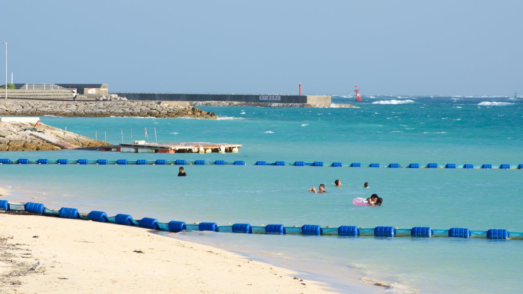 Okinawa showing swimming, a beach and rugged coastline