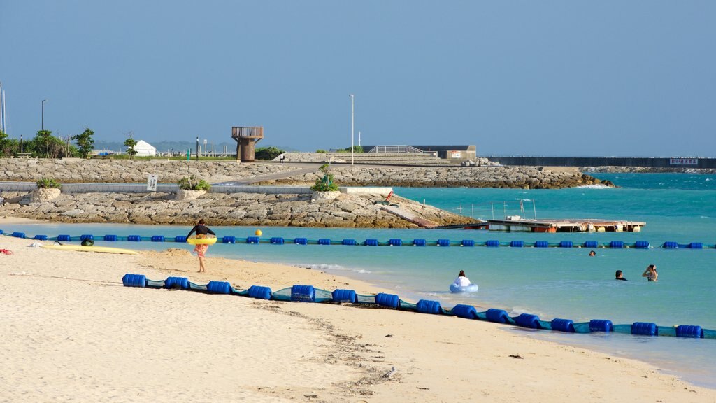 Okinawa showing a sandy beach, rocky coastline and swimming