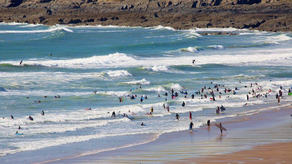 Croyde caracterizando natação e uma praia de areia assim como um grande grupo de pessoas