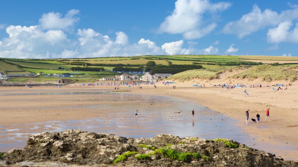 Croyde que inclui uma praia de areia assim como um grande grupo de pessoas