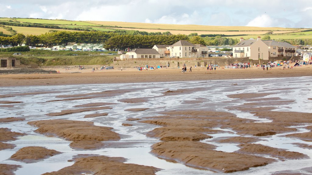 Croyde showing a sandy beach and a coastal town as well as a large group of people