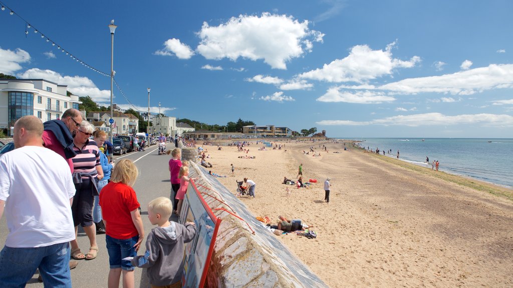 Exmouth featuring a sandy beach and a coastal town as well as a large group of people