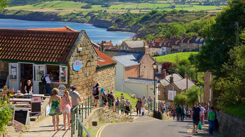 Playa de Robin Hood\'s Bay mostrando una ciudad costera y escenas urbanas y también un gran grupo de personas