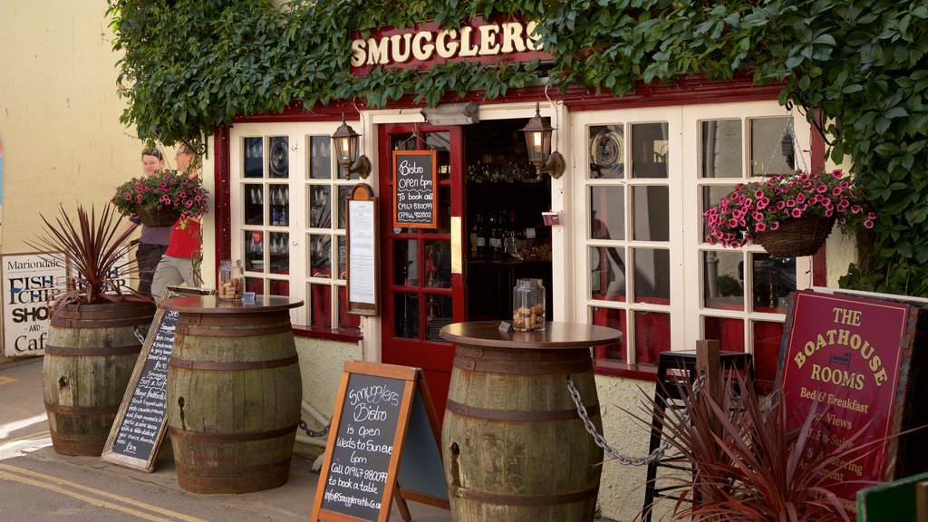 Playa de Robin Hood\'s Bay que incluye señalización, una ciudad costera y escenas de café