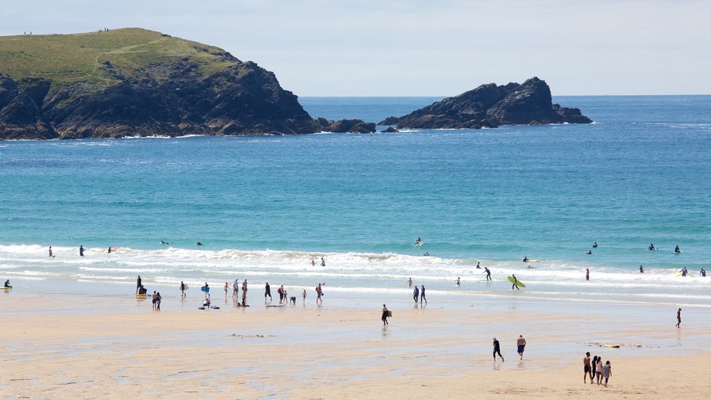 Fistral Beach which includes a sandy beach and swimming as well as a large group of people