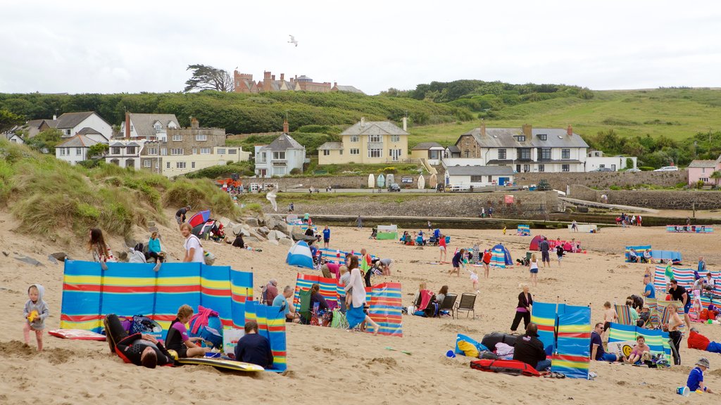 Bude Beach featuring a beach and a coastal town as well as a large group of people