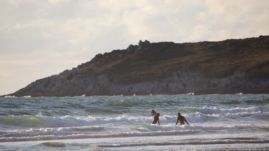 Woolacombe montrant baignade, côte rocheuse et vagues