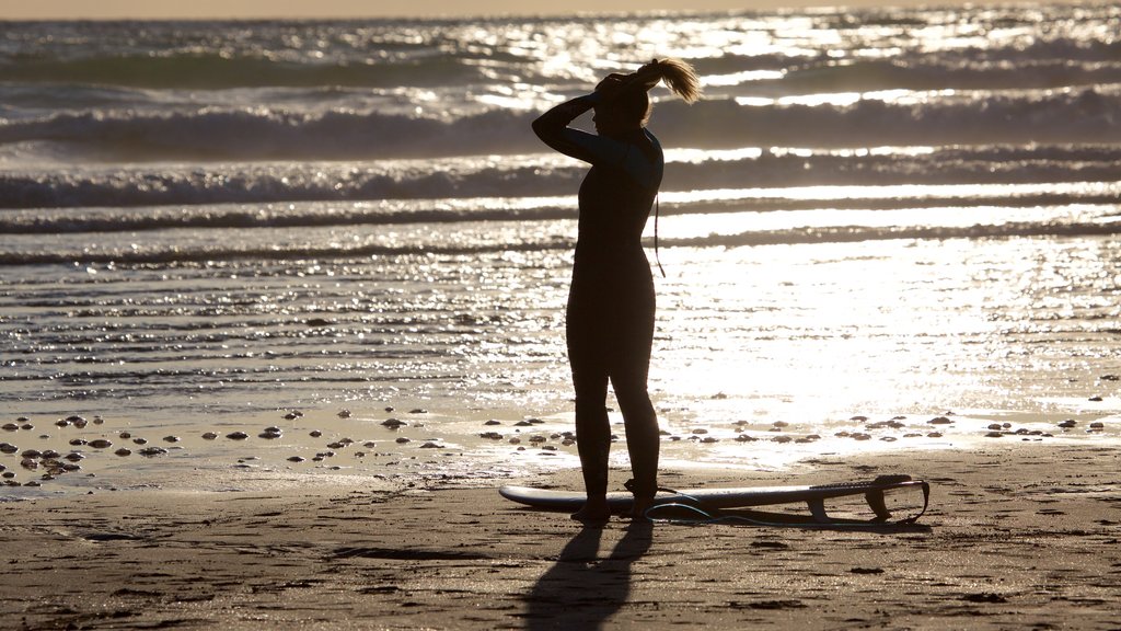 Woolacombe mostrando uma praia e surfe assim como uma mulher sozinha