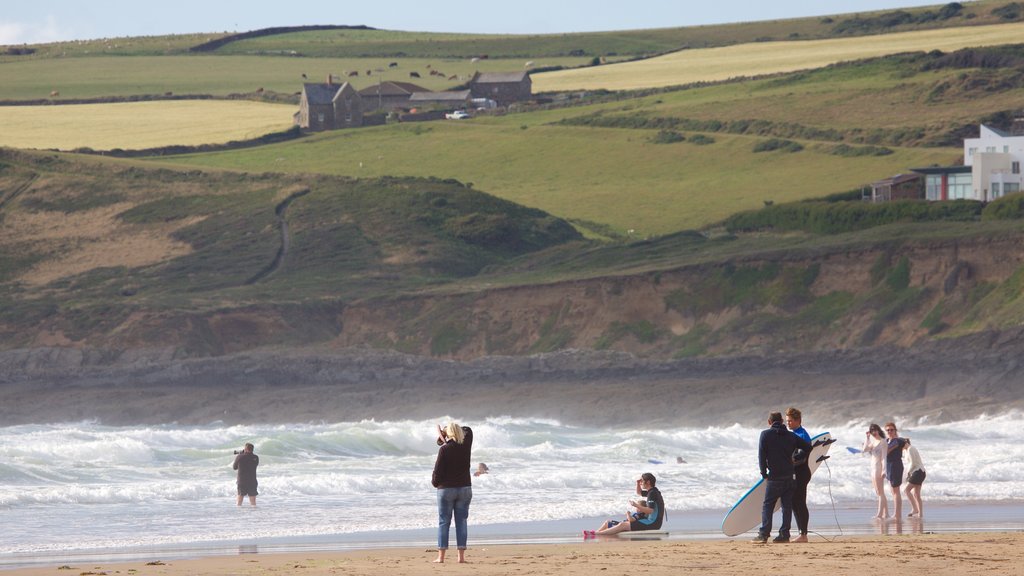 Croyde mostrando una playa de arena y surf y también un pequeño grupo de personas