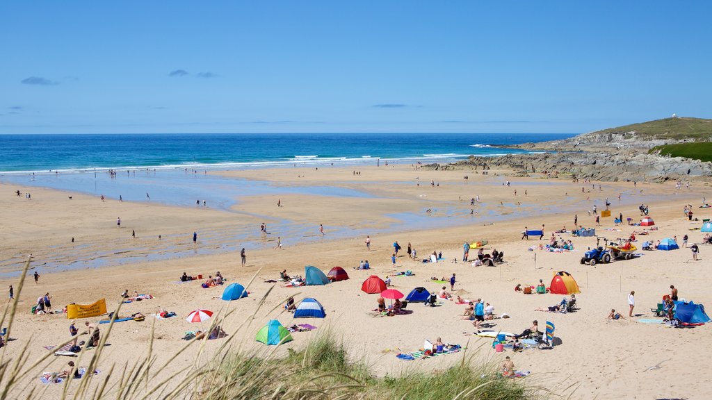 Fistral Beach que inclui uma praia assim como um grande grupo de pessoas