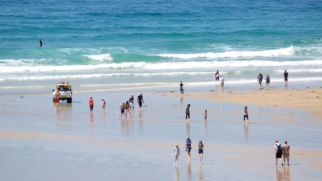 Fistral Beach which includes surf and a beach as well as a large group of people