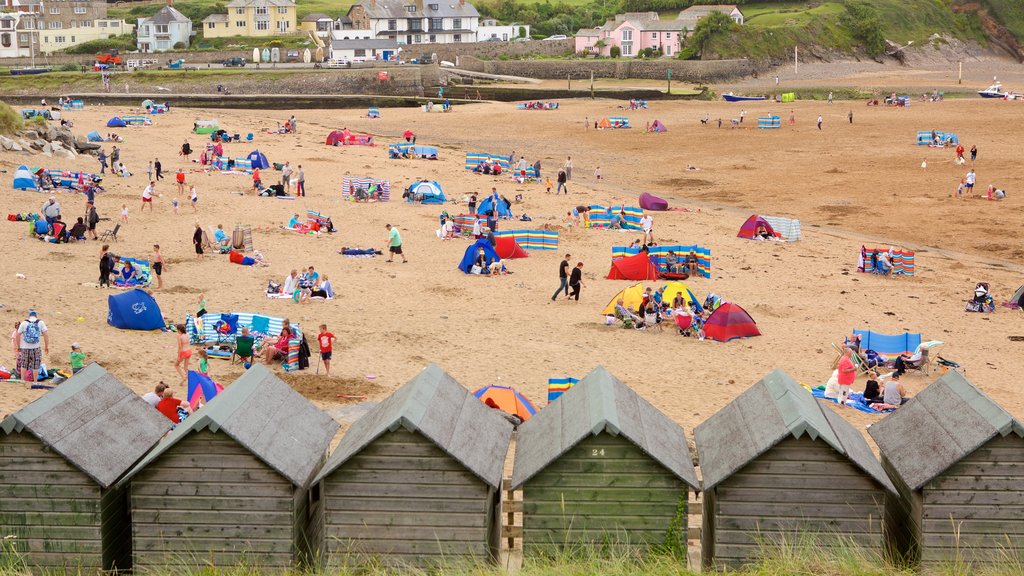 Bude Beach showing a house and a sandy beach as well as a large group of people