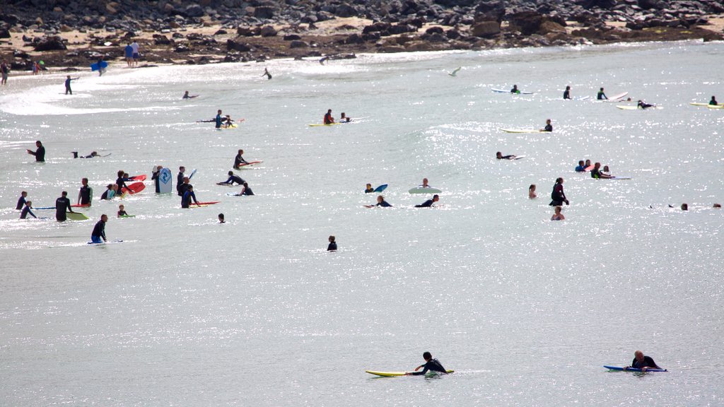 Porthmeor Beach showing surfing, a beach and swimming