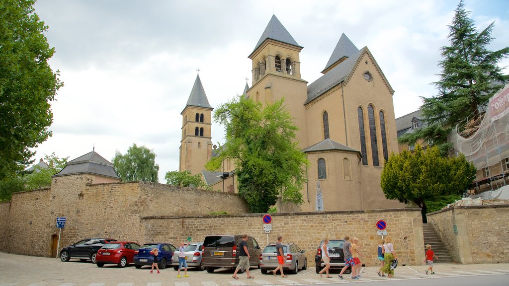 Echternach ofreciendo una iglesia o catedral y arquitectura patrimonial y también un pequeño grupo de personas