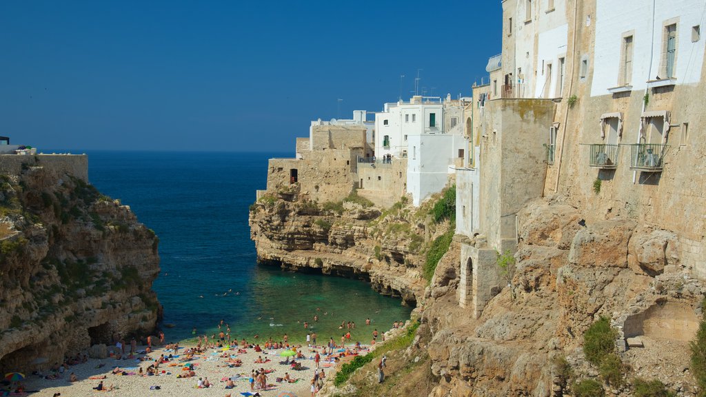 Polignano a Mare mettant en vedette une plage de galets, rochers au bord de la mer et une ville côtière