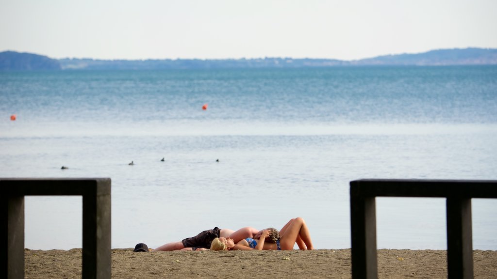 Lago de Bolsena mostrando una playa de arena y vista general a la costa y también una pareja