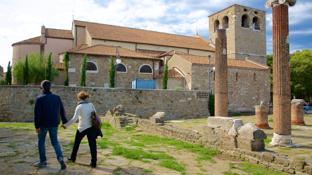 Cathedral of San Giusto featuring a ruin as well as a couple