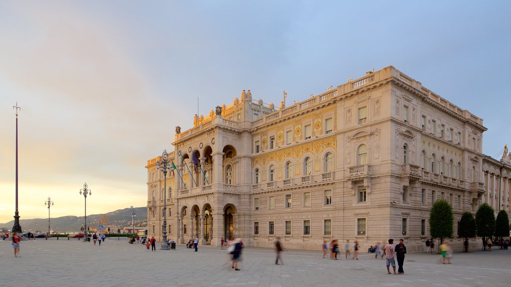 Piazza dell\'Unita ofreciendo arquitectura patrimonial, una plaza y un atardecer