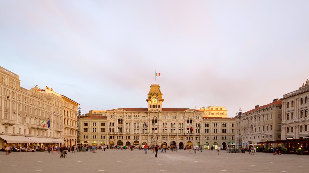 Piazza dell\'Unita que inclui um pôr do sol, uma praça ou plaza e um edifício administrativo