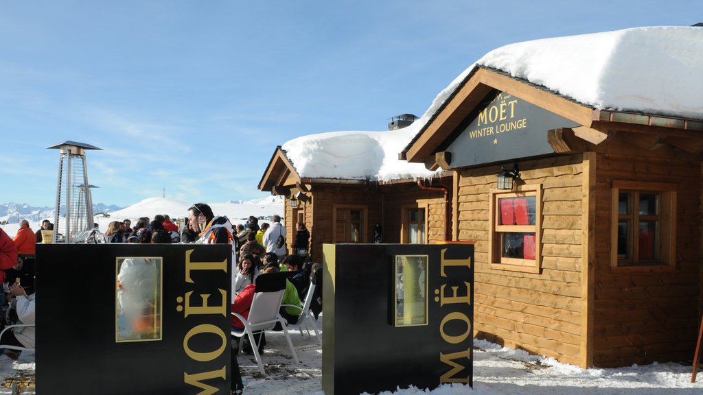 Baqueira Beret Ski Resort showing signage and snow as well as a large group of people